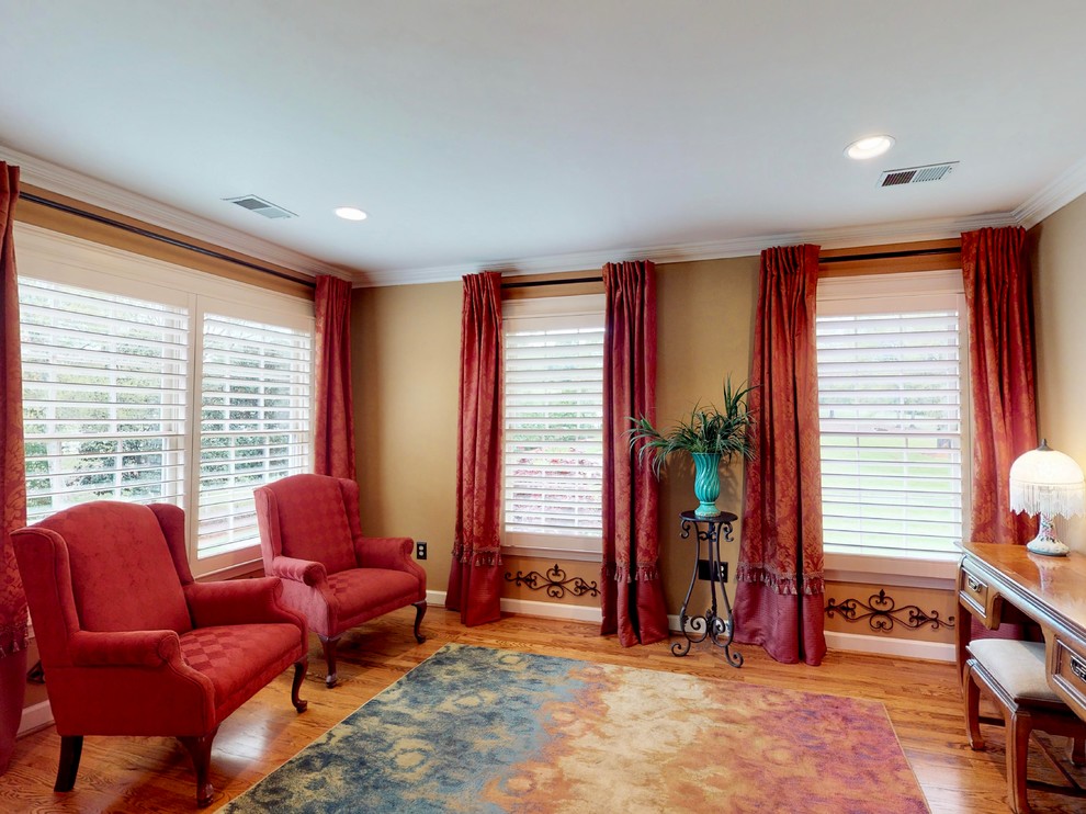 Mittelgroßes Hauptschlafzimmer mit beiger Wandfarbe, hellem Holzboden, Kamin und gefliester Kaminumrandung in Sonstige