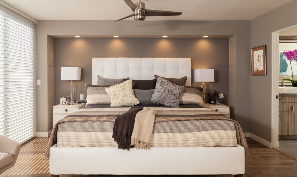 Imagen de dormitorio principal contemporáneo de tamaño medio sin chimenea con paredes grises, suelo de madera en tonos medios y suelo marrón