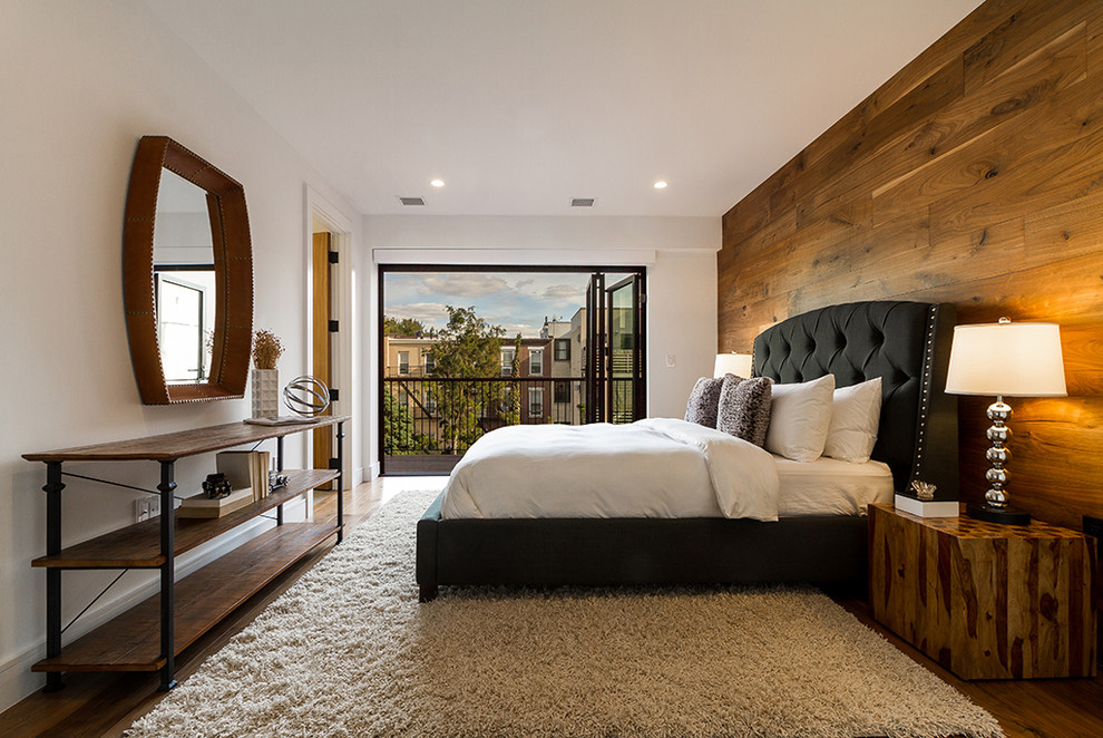 Mittelgroßes Modernes Hauptschlafzimmer ohne Kamin mit weißer Wandfarbe, braunem Holzboden und beigem Boden in New York