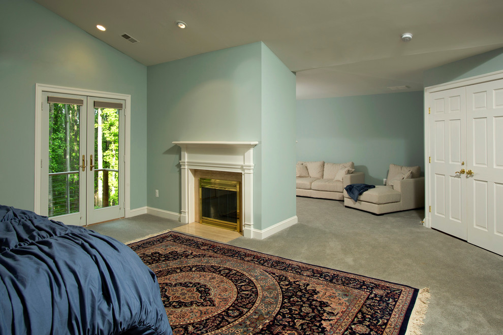 На фото: огромная хозяйская спальня в классическом стиле с синими стенами, ковровым покрытием, стандартным камином и фасадом камина из металла с