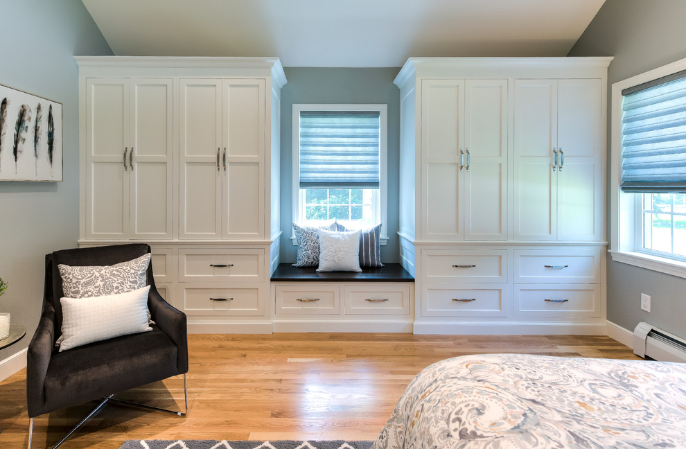 Imagen de dormitorio principal tradicional de tamaño medio sin chimenea con paredes grises, suelo de madera en tonos medios y suelo marrón