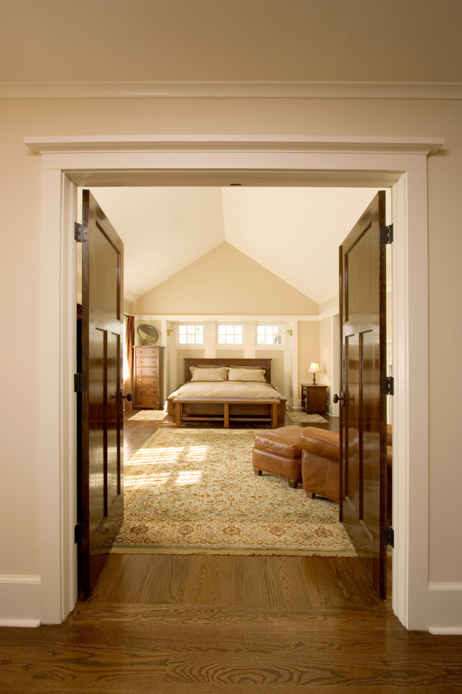 Foto di una grande camera matrimoniale stile americano con pareti beige e pavimento in legno massello medio