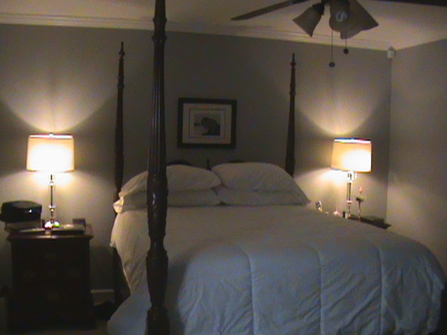 Esempio di una piccola camera matrimoniale classica con pareti grigie e pavimento in legno massello medio