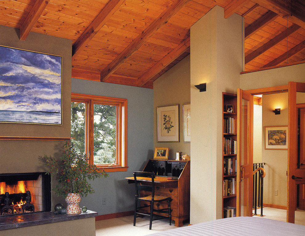 Idée de décoration pour une grande chambre design avec un mur beige, une cheminée standard et un manteau de cheminée en plâtre.