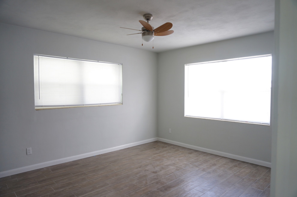 Kleines Retro Hauptschlafzimmer mit grauer Wandfarbe, Porzellan-Bodenfliesen und braunem Boden in Orlando