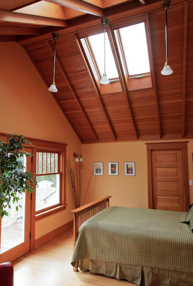 Réalisation d'une très grande chambre parentale craftsman avec un mur orange et parquet clair.