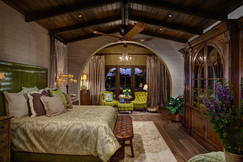 На фото: большая хозяйская спальня в средиземноморском стиле с бежевыми стенами, темным паркетным полом и коричневым полом