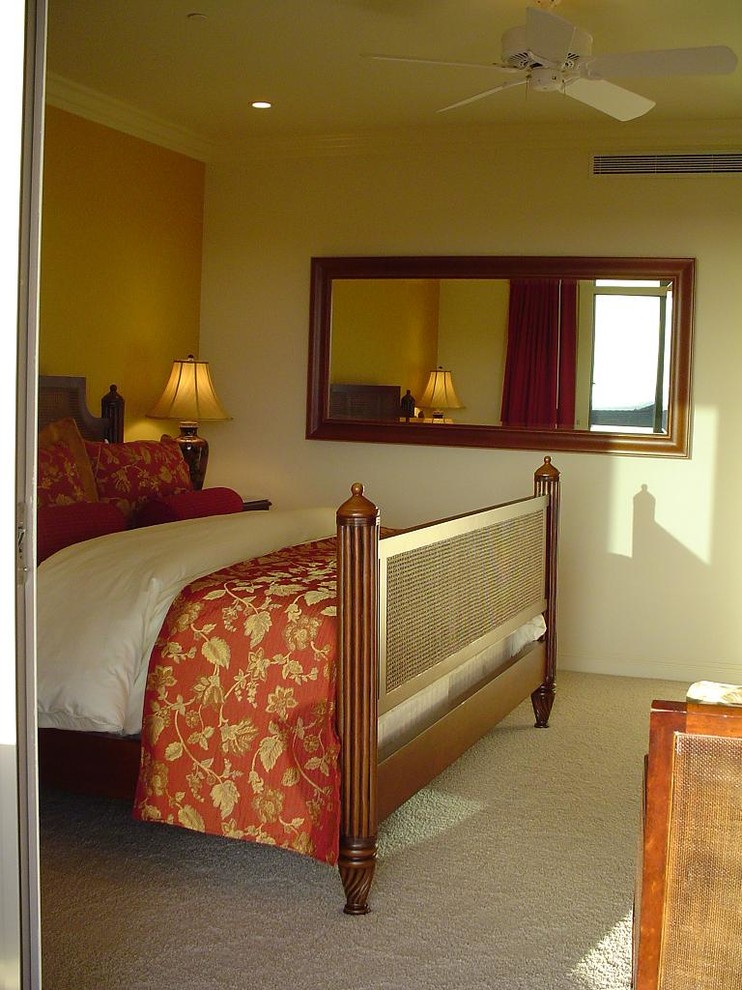 Modelo de dormitorio principal exótico con paredes amarillas y moqueta
