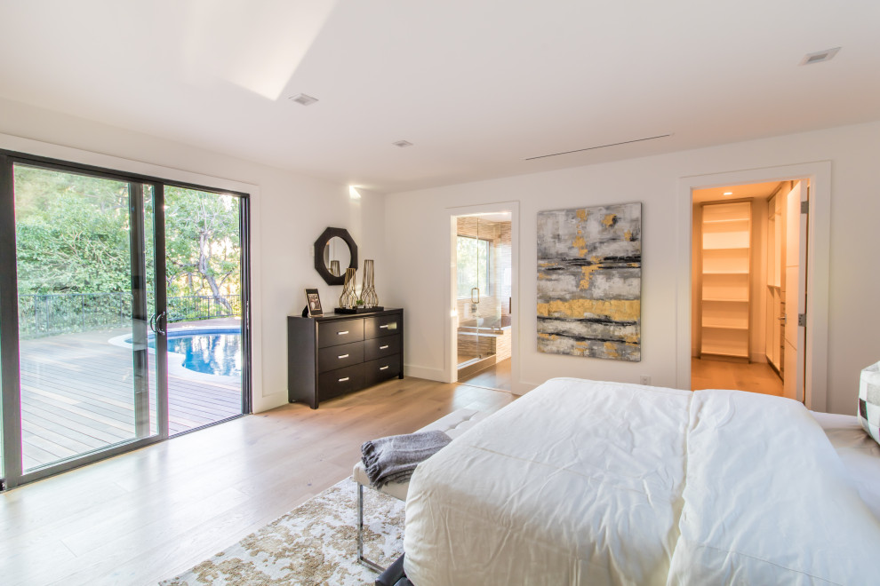Mittelgroßes Modernes Hauptschlafzimmer ohne Kamin mit weißer Wandfarbe, hellem Holzboden und beigem Boden in Los Angeles