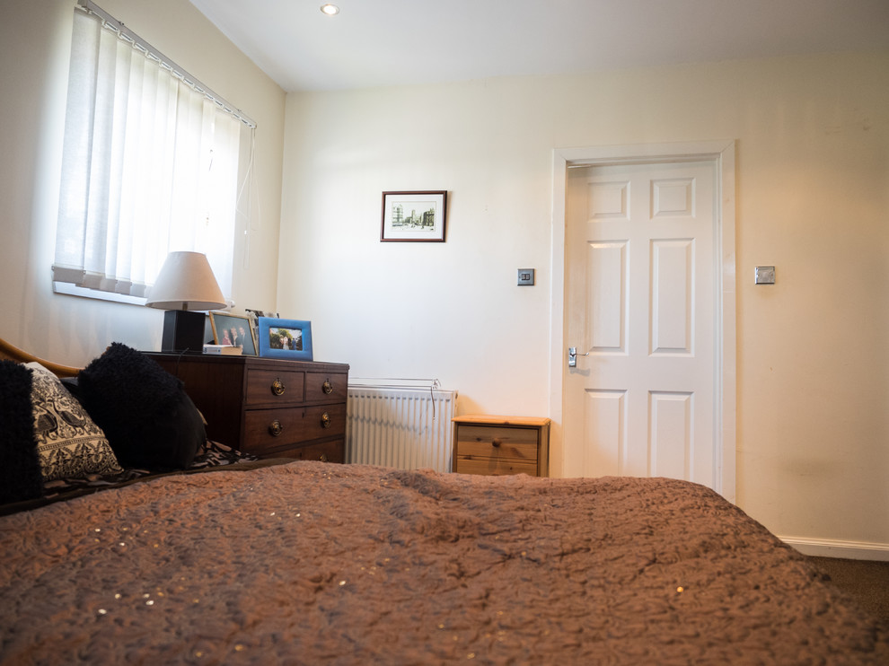Esempio di una piccola camera da letto eclettica con pareti beige e moquette