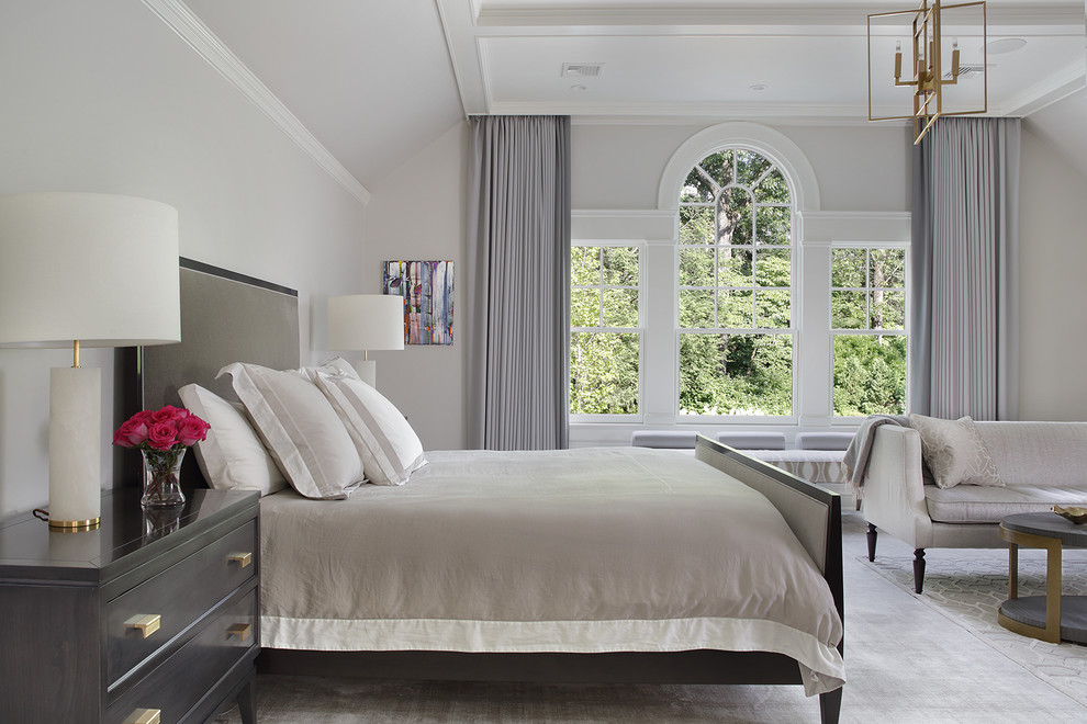Modelo de dormitorio principal clásico grande con paredes grises, moqueta, todas las chimeneas, marco de chimenea de yeso y suelo beige