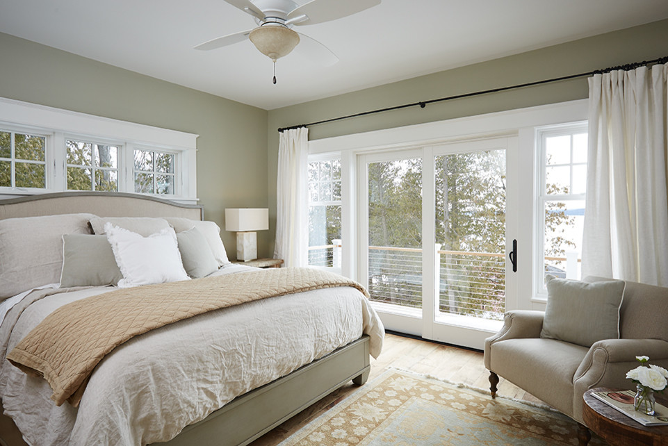Imagen de dormitorio principal marinero de tamaño medio sin chimenea con paredes verdes y suelo de madera en tonos medios