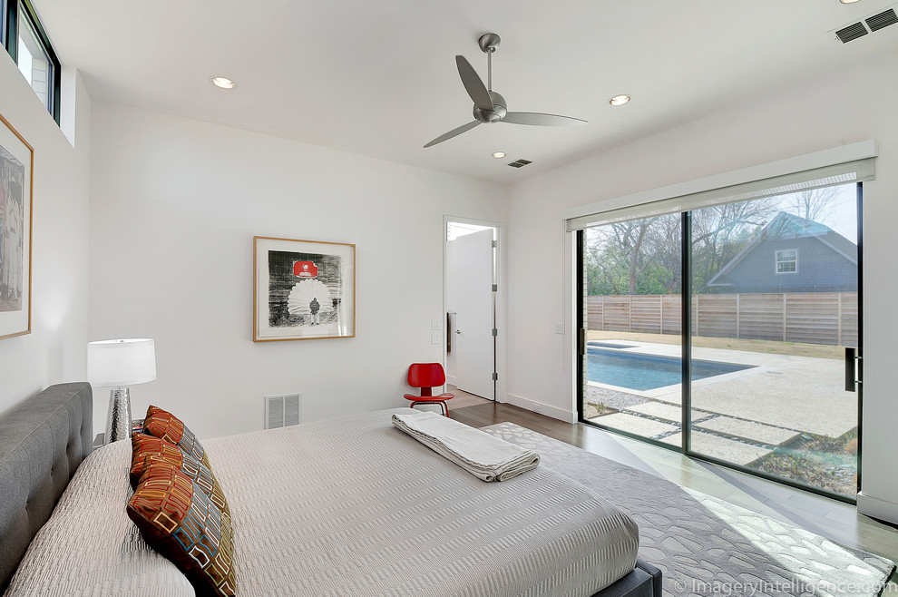 Example of a mid-sized trendy master medium tone wood floor bedroom design in Dallas with white walls