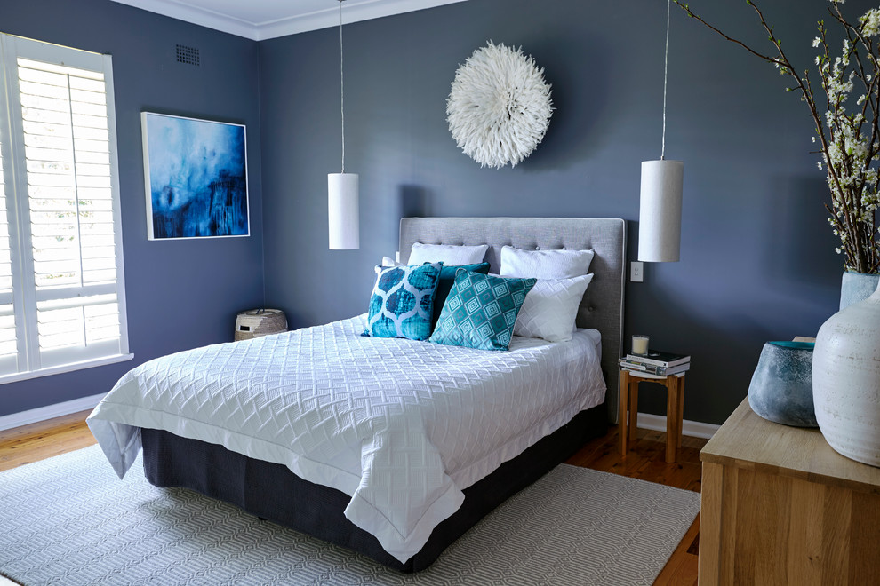 Imagen de dormitorio principal actual de tamaño medio con paredes grises y suelo de madera en tonos medios