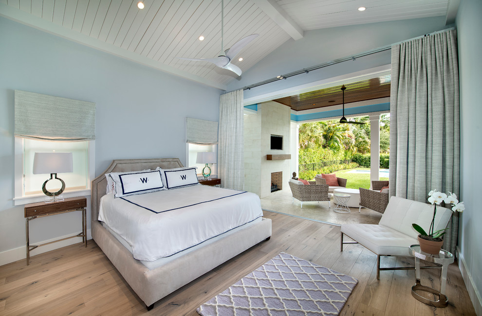На фото: хозяйская спальня: освещение в морском стиле с синими стенами и светлым паркетным полом без камина с