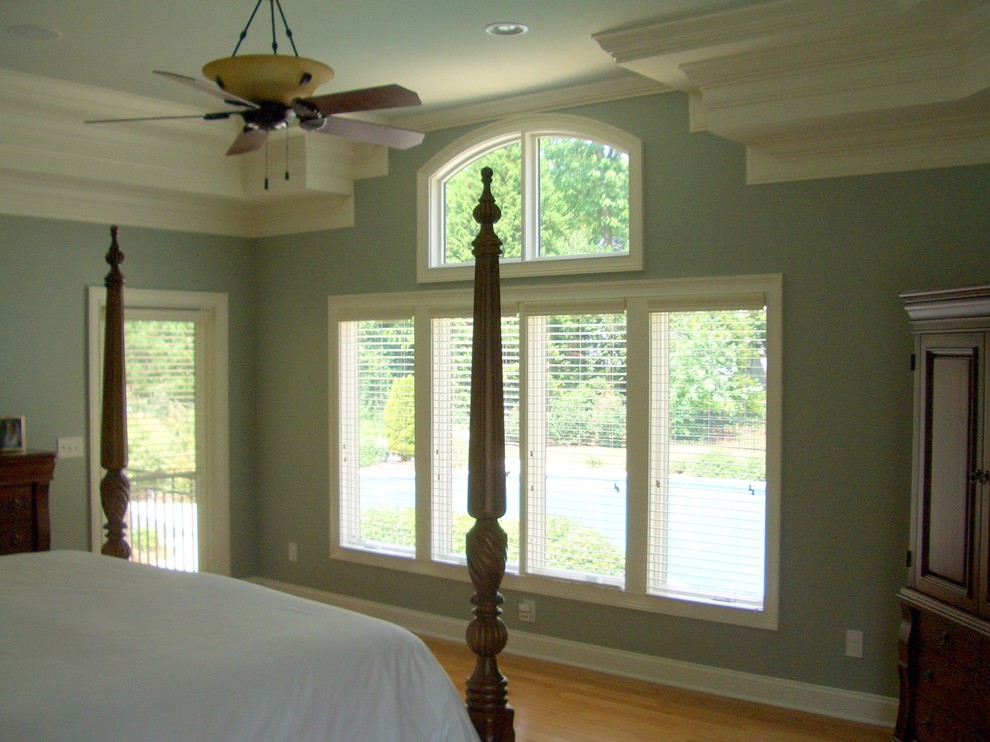 Ejemplo de dormitorio principal tradicional renovado grande sin chimenea con paredes azules y suelo de madera en tonos medios