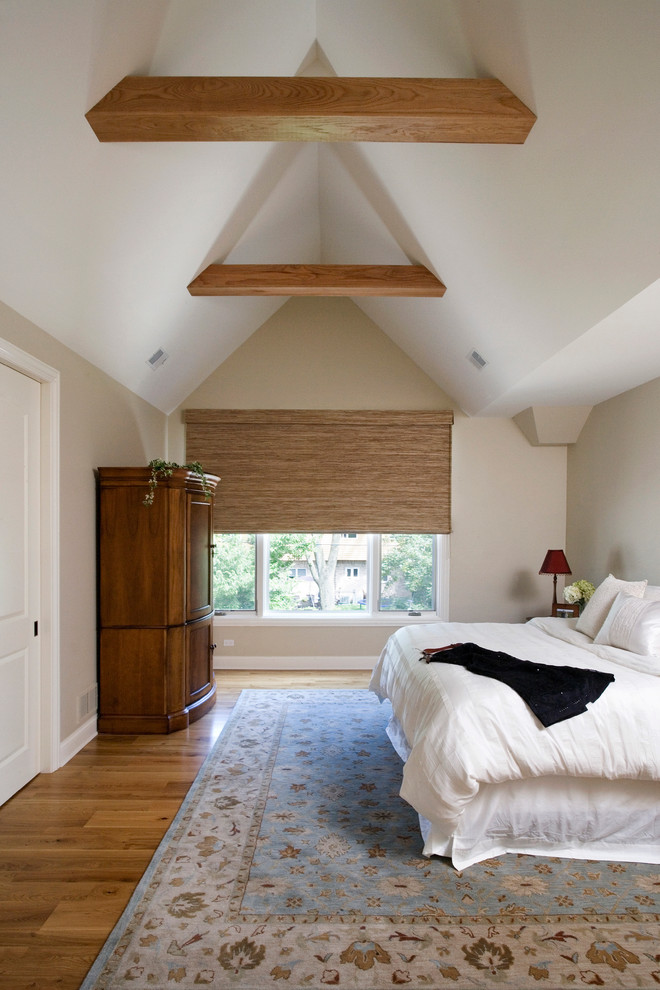 Modelo de dormitorio principal clásico grande sin chimenea con paredes beige y suelo de madera clara