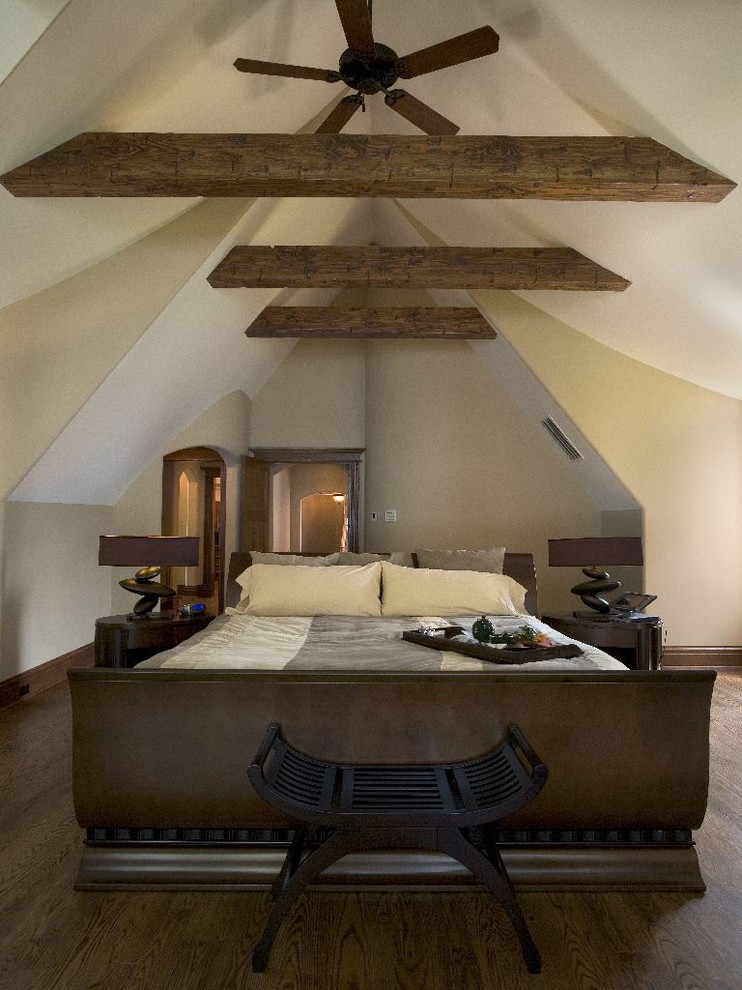 This is an example of an expansive rustic master bedroom in Chicago with beige walls and dark hardwood flooring.
