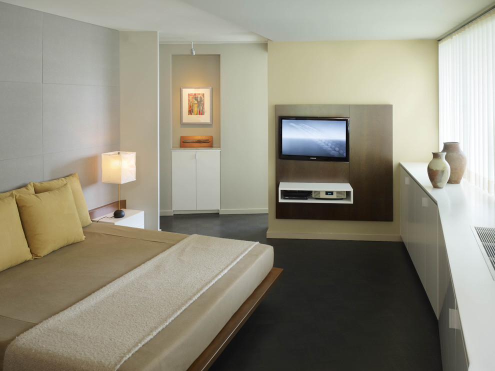 Стильный дизайн: хозяйская спальня в современном стиле с бежевыми стенами, бетонным полом, серым полом и телевизором без камина - последний тренд