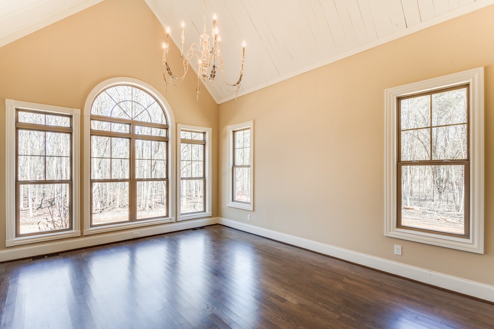 Immagine di una grande camera matrimoniale chic con pareti beige e pavimento in legno massello medio