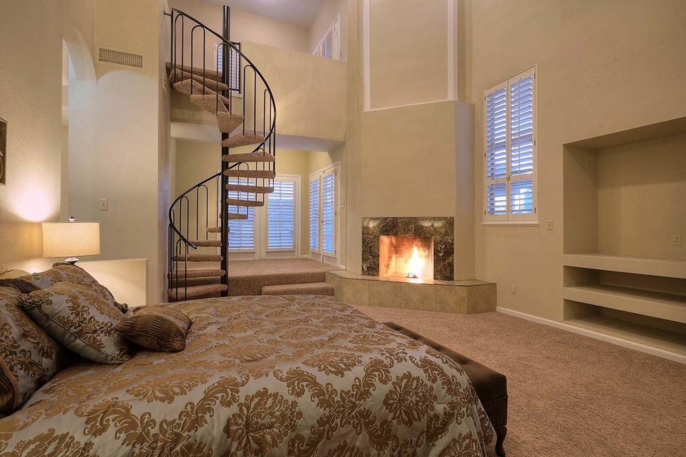Tuscan master carpeted bedroom photo in Phoenix with beige walls, a corner fireplace and a stone fireplace