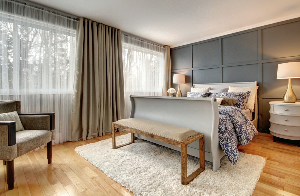 Ejemplo de dormitorio principal clásico renovado grande con paredes azules, suelo de madera clara y suelo beige