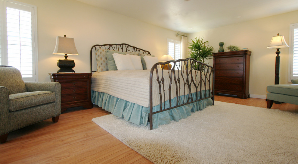 Modelo de dormitorio tradicional con paredes blancas y suelo de madera clara