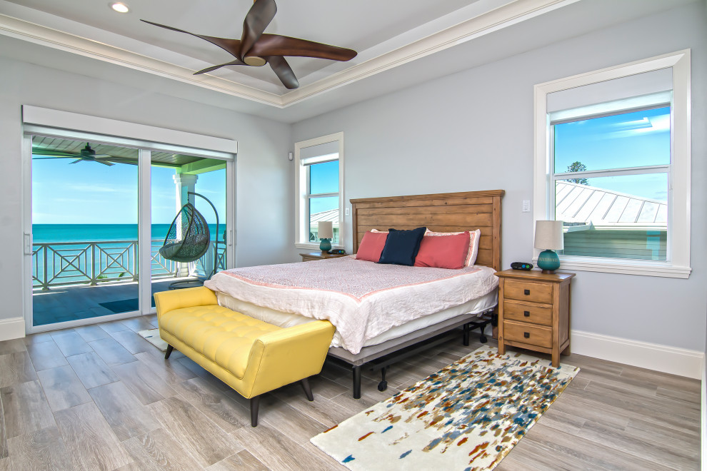 Medium sized beach style bedroom in Miami with grey walls, medium hardwood flooring and grey floors.