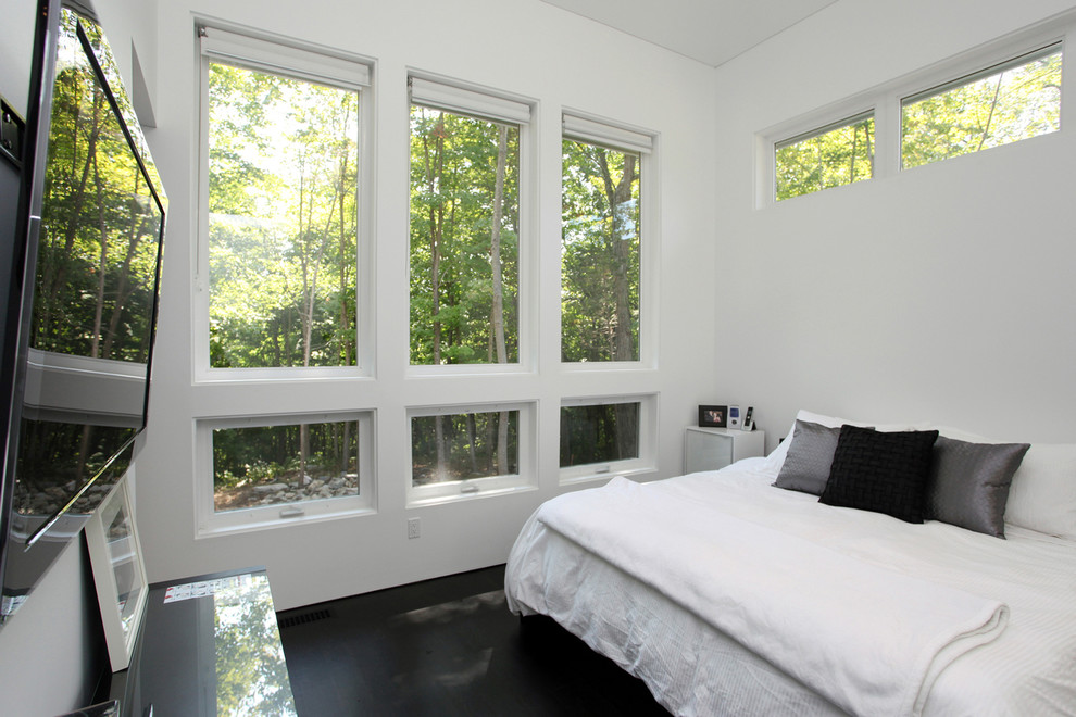 Modernes Hauptschlafzimmer ohne Kamin mit weißer Wandfarbe und dunklem Holzboden in New York
