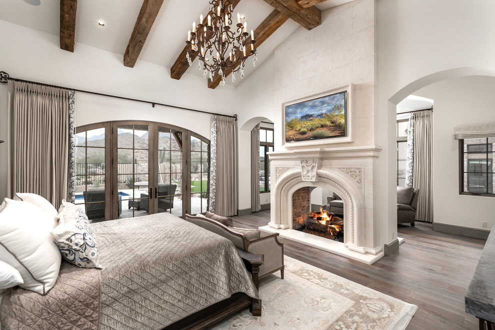 フェニックスにある巨大なトランジショナルスタイルのおしゃれな主寝室 (白い壁、濃色無垢フローリング、暖炉なし、石材の暖炉まわり、茶色い床) のインテリア