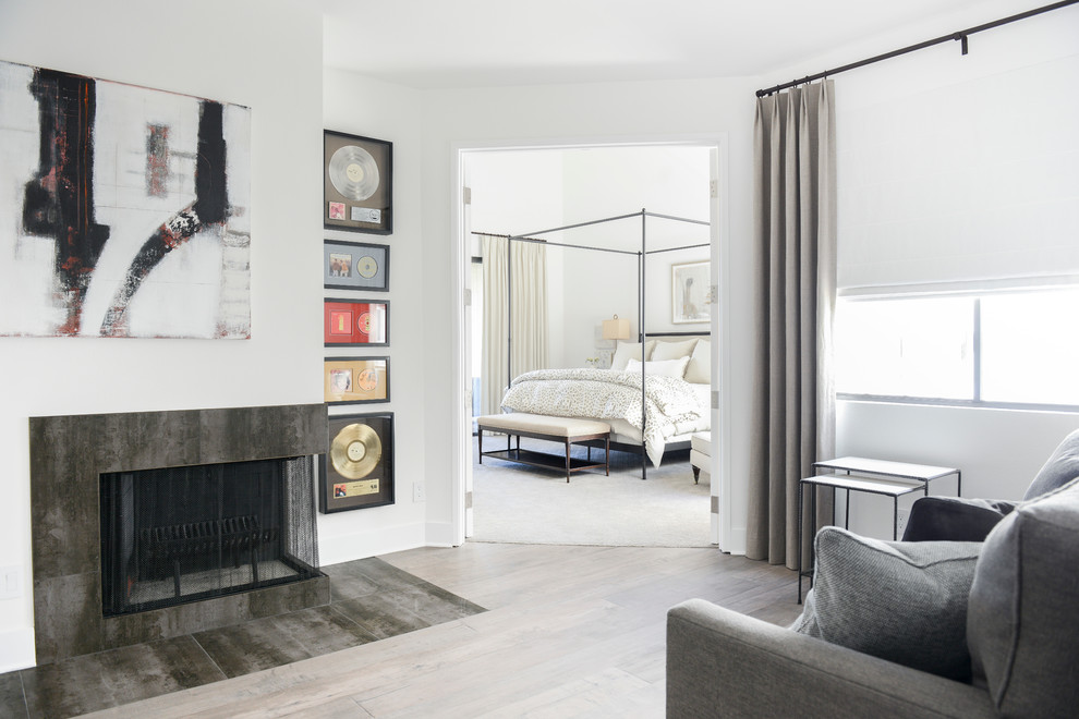Стильный дизайн: большая хозяйская спальня в современном стиле с белыми стенами, угловым камином и фасадом камина из плитки - последний тренд