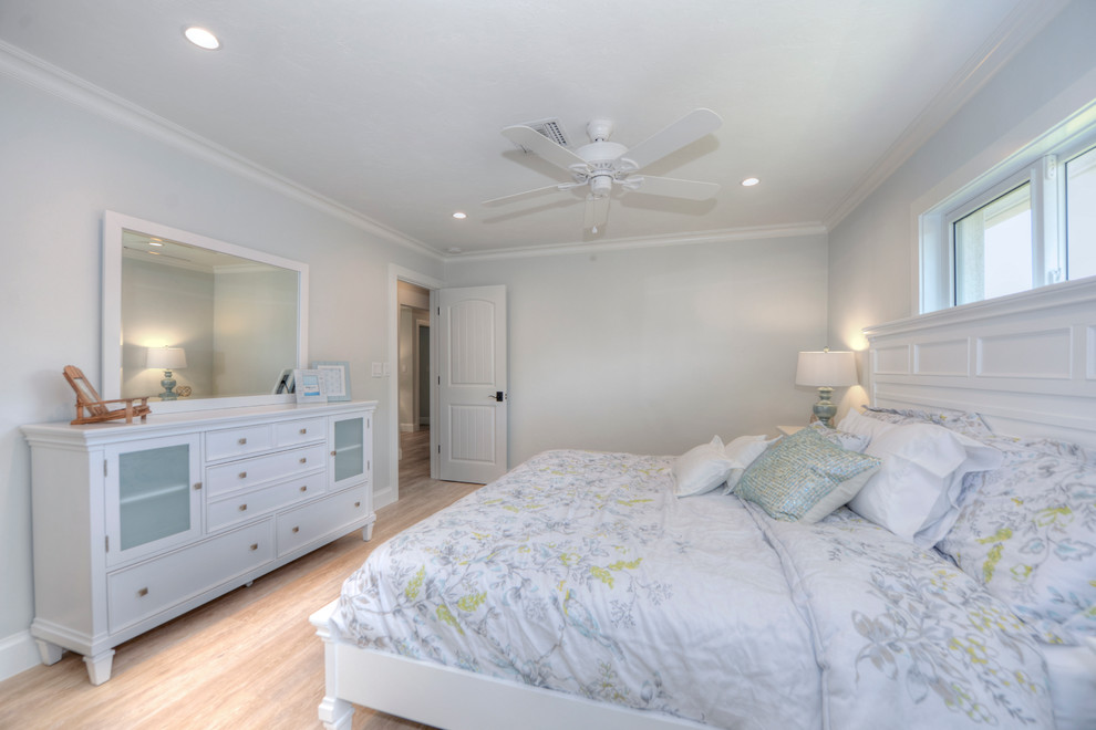 Modelo de dormitorio costero con suelo de madera clara