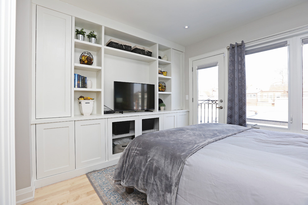 Traditional master bedroom in Toronto with blue walls, light hardwood flooring and no fireplace.