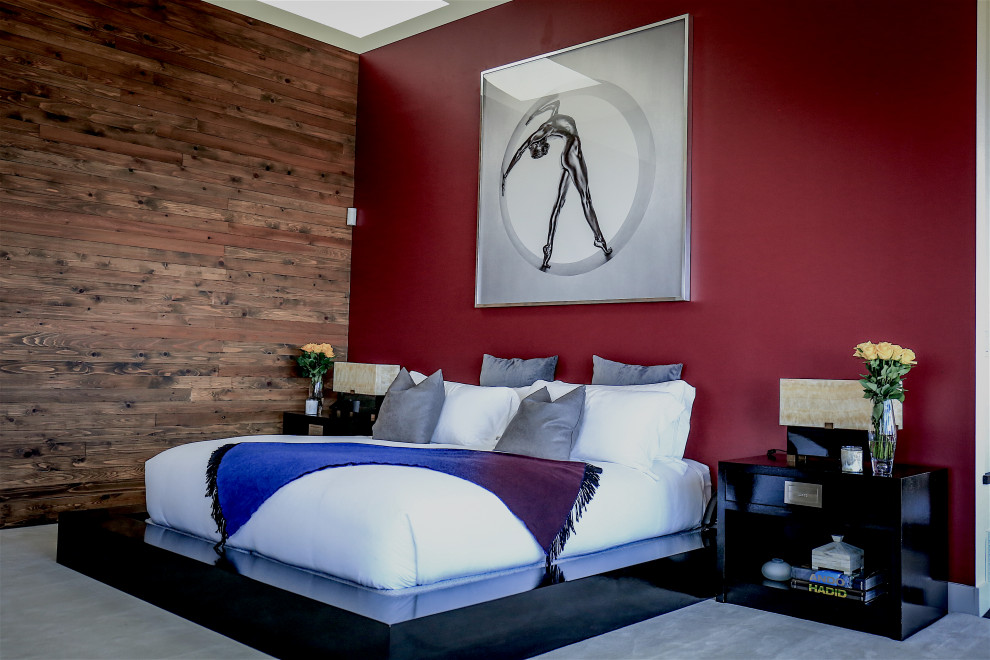 На фото: большая хозяйская спальня с красными стенами, ковровым покрытием, стандартным камином и белым полом с