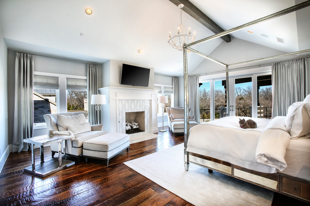 Large transitional master medium tone wood floor and brown floor bedroom photo in Dallas with gray walls, a standard fireplace and a stone fireplace