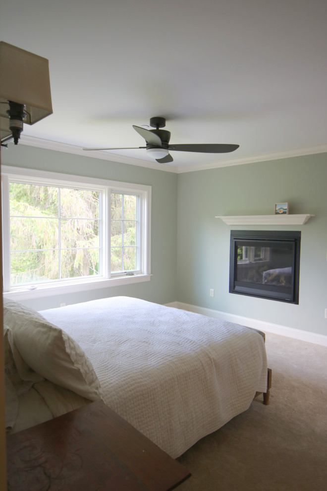 Ejemplo de dormitorio principal tradicional de tamaño medio con paredes azules, moqueta, chimenea lineal, marco de chimenea de metal y suelo beige