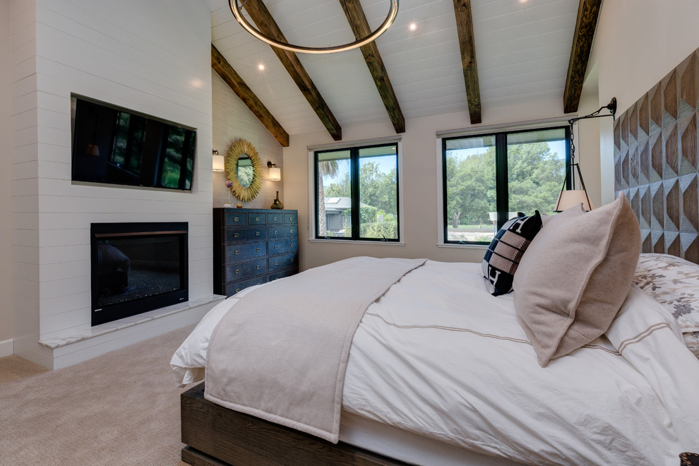 Идея дизайна: большая хозяйская спальня в стиле модернизм с бежевыми стенами, ковровым покрытием, стандартным камином, фасадом камина из дерева и бежевым полом