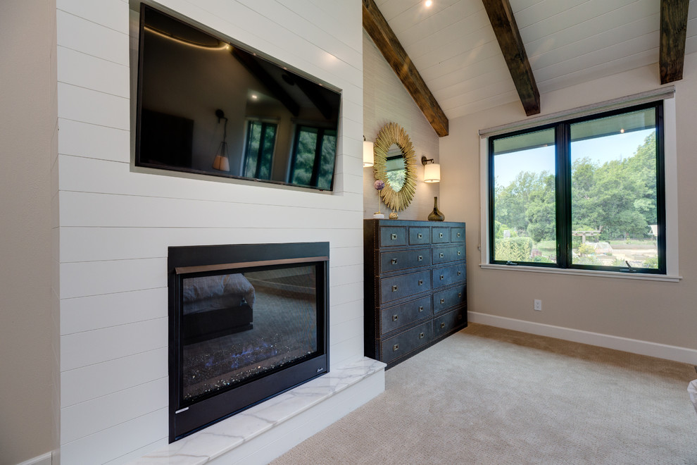 Idée de décoration pour une grande chambre minimaliste avec un mur beige, une cheminée standard, un manteau de cheminée en bois et un sol beige.