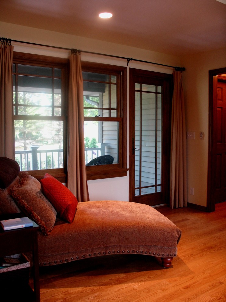 Ejemplo de dormitorio principal tradicional grande con suelo de madera en tonos medios, suelo marrón y paredes blancas