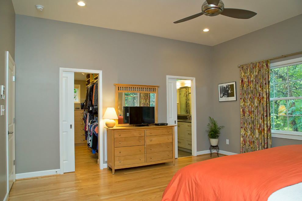 Пример оригинального дизайна: большая хозяйская спальня в современном стиле с серыми стенами, паркетным полом среднего тона и оранжевым полом