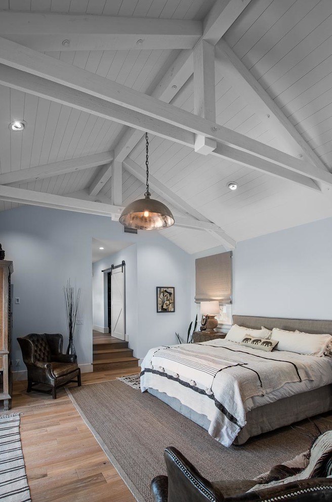 На фото: хозяйская спальня среднего размера в стиле рустика с серыми стенами, светлым паркетным полом и коричневым полом