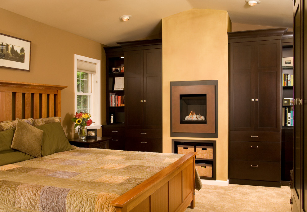 На фото: хозяйская спальня в классическом стиле с коричневыми стенами, ковровым покрытием и стандартным камином