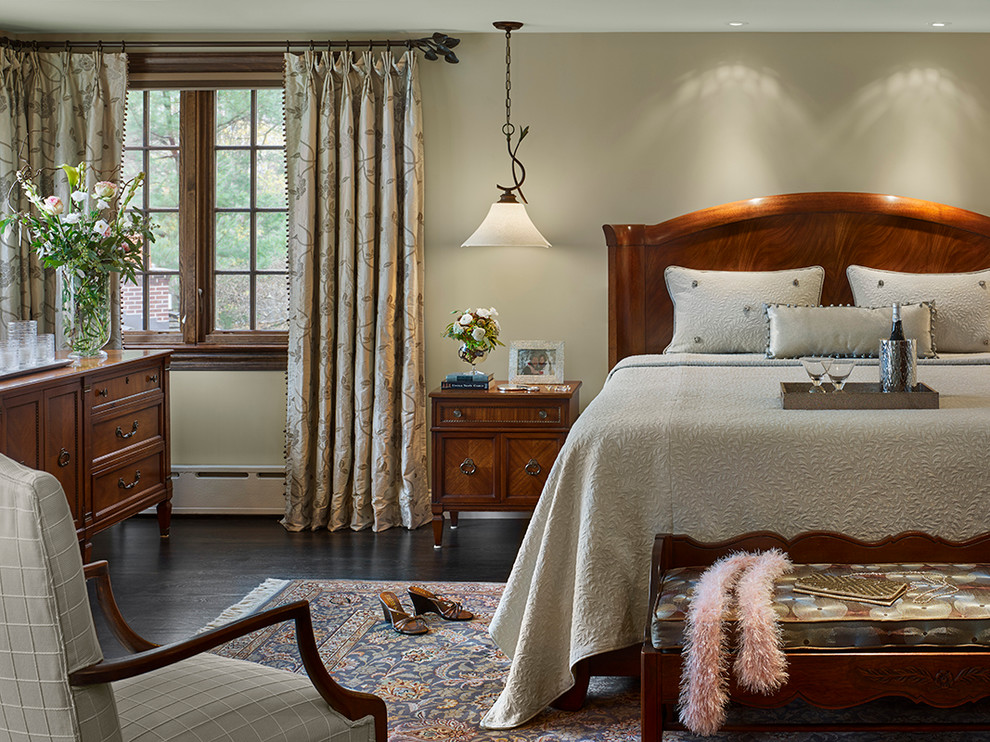 Inspiration for a large traditional master bedroom in Other with beige walls, dark hardwood flooring and a stone fireplace surround.