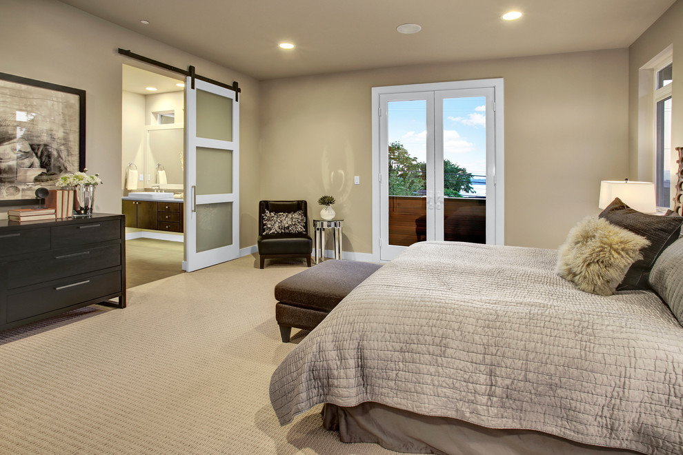 This is an example of a contemporary master bedroom in Seattle with beige walls, carpet and no fireplace.