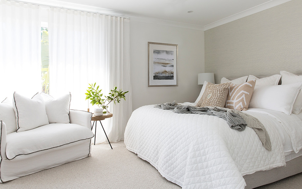 Modelo de dormitorio principal costero grande con paredes blancas, moqueta y suelo gris
