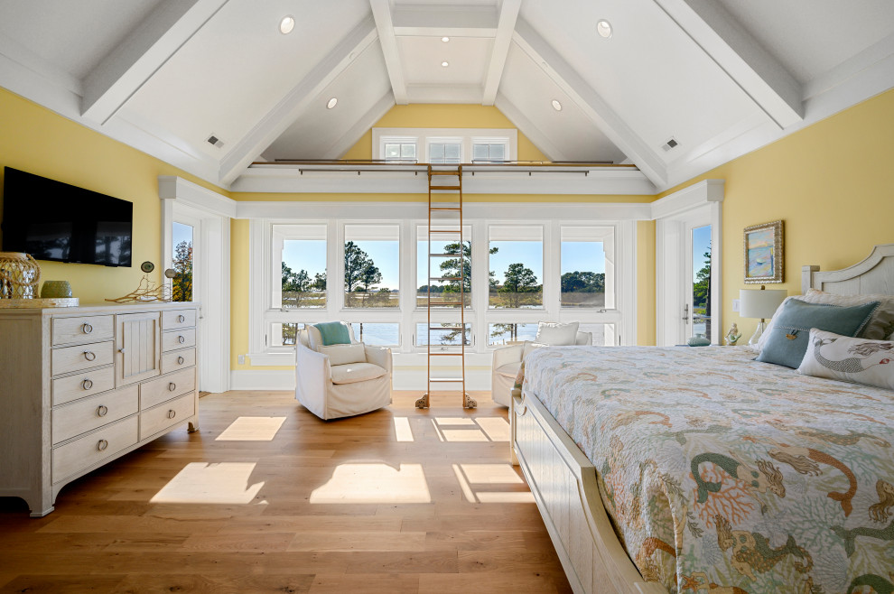 Example of a large transitional master medium tone wood floor and brown floor bedroom design with yellow walls and no fireplace