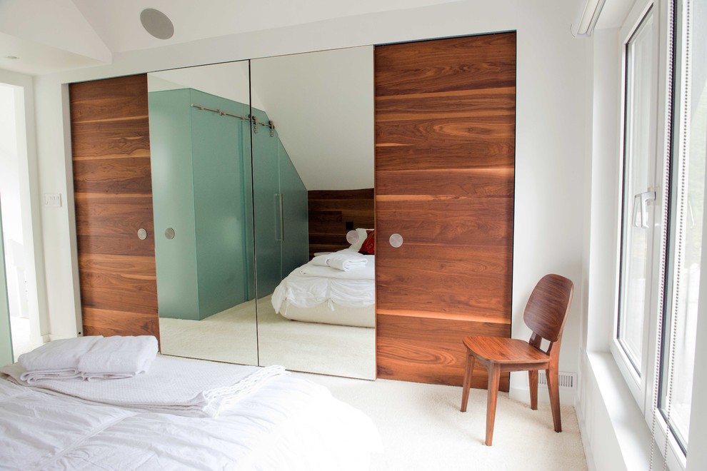 Imagen de dormitorio tipo loft contemporáneo de tamaño medio con paredes blancas y moqueta
