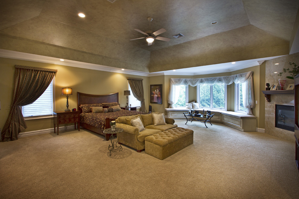 Geräumiges Klassisches Hauptschlafzimmer mit Kamin, Kaminumrandung aus Stein, brauner Wandfarbe, Teppichboden und beigem Boden in New York