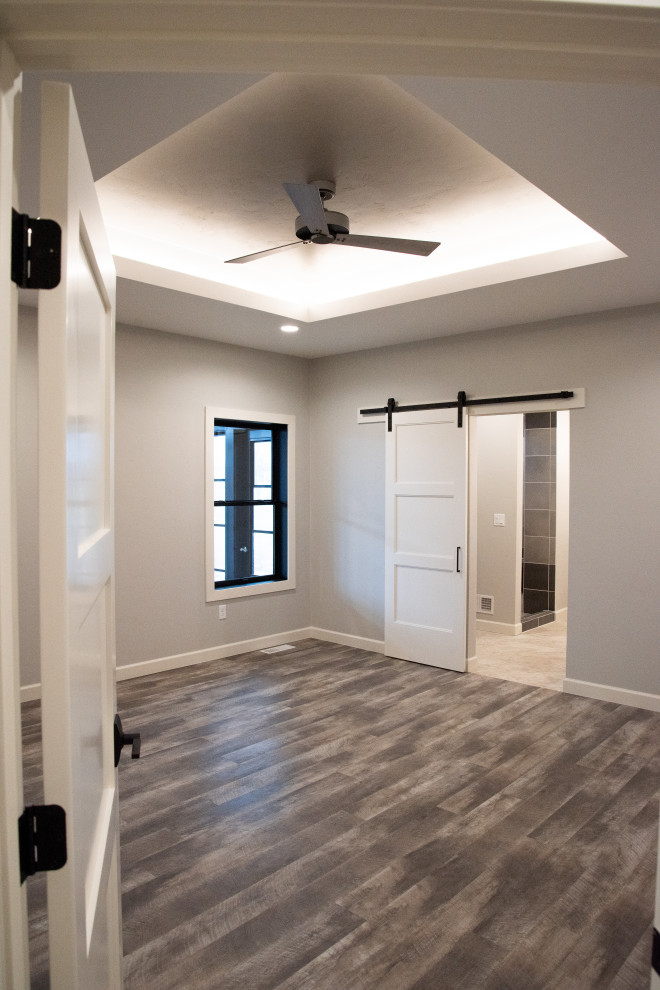 Idée de décoration pour une grande chambre parentale minimaliste avec un mur gris, un sol en vinyl, un sol marron et un plafond décaissé.