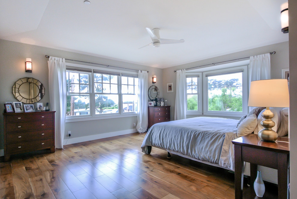 Ejemplo de dormitorio principal marinero de tamaño medio con paredes azules y suelo de madera en tonos medios